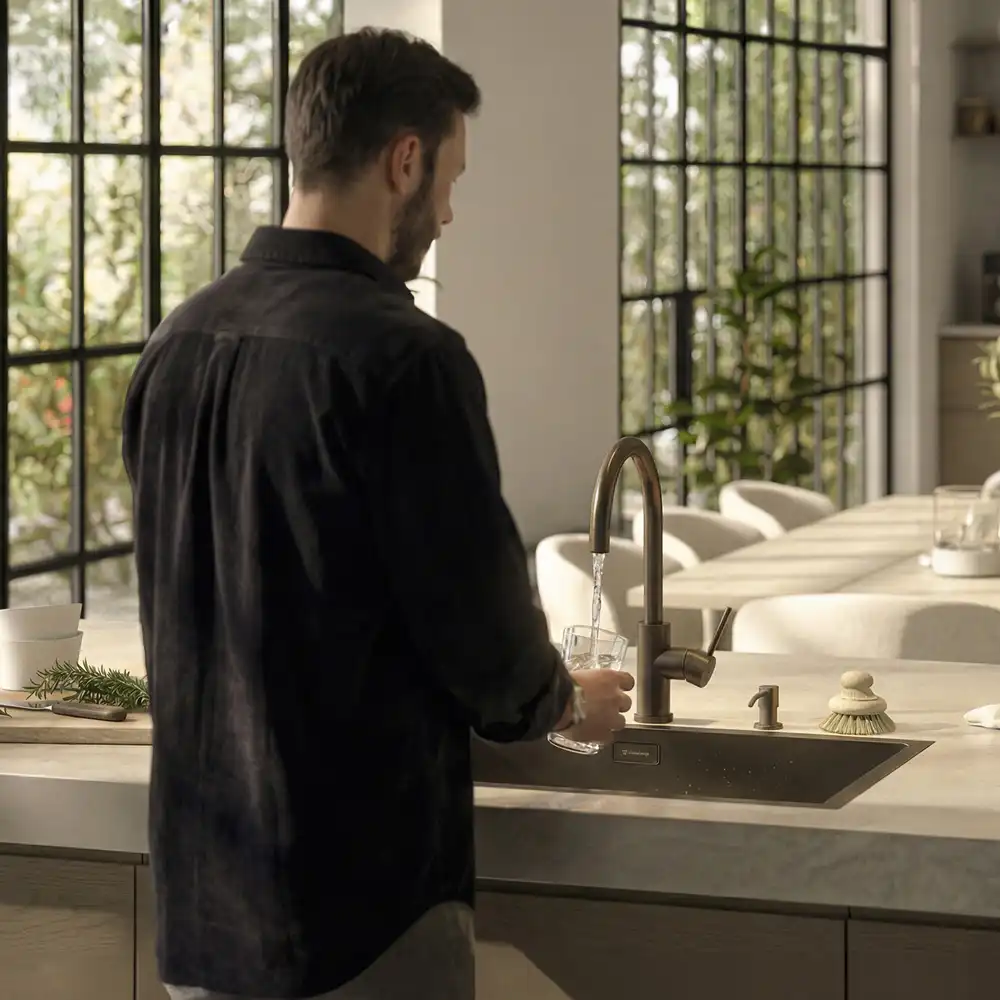 Erik tar vatten. Köksblandare borstad brons